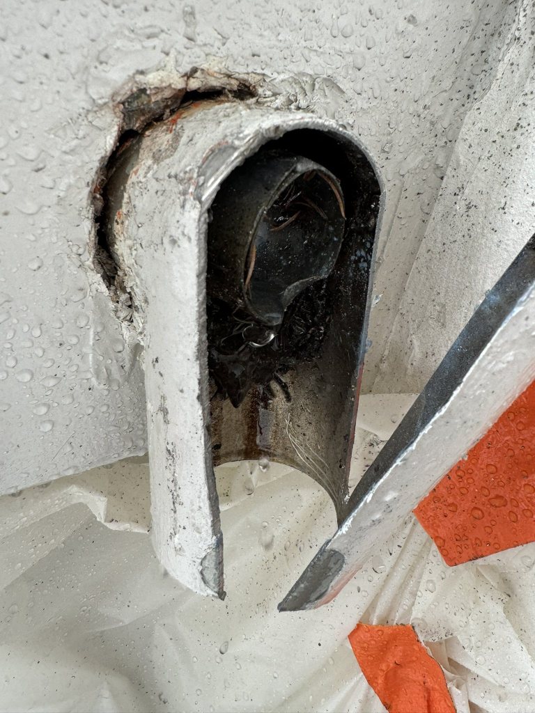 Canalisation ouverte montrant son intérieur et des dépôts.